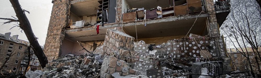 A partly destroyed residential building in Kyiv reflects urban devastation.