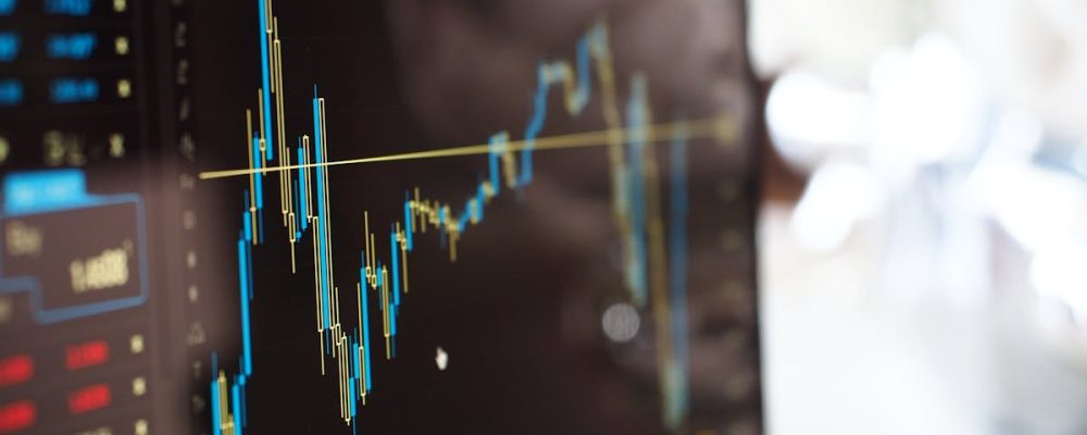 Detailed view of financial trading graphs on a monitor, illustrating stock market trends.