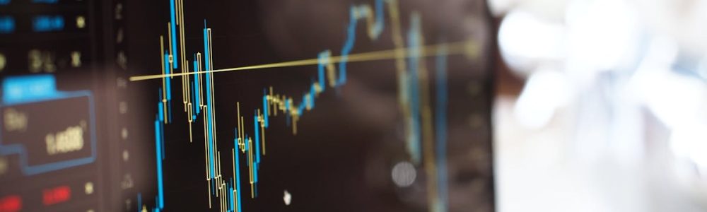 Detailed view of financial trading graphs on a monitor, illustrating stock market trends.
