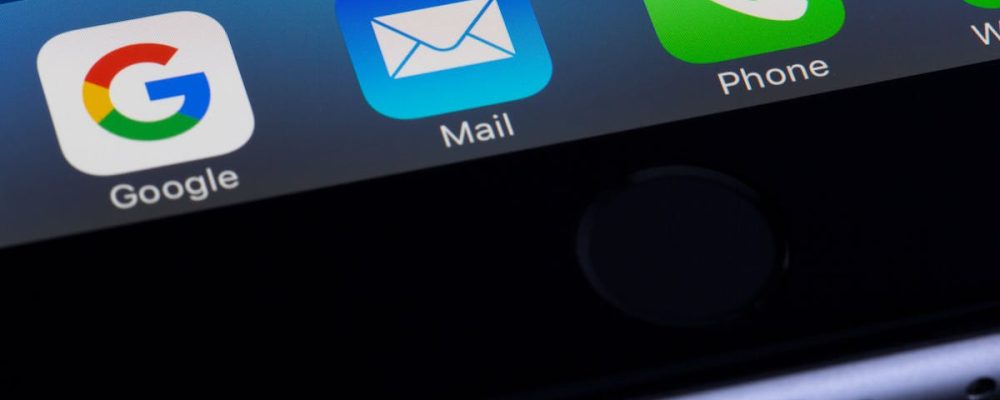 A close-up photo of a smartphone displaying popular apps like Google and Mail.