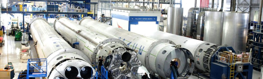 View of a spacecraft assembly line with rockets in a spacious hangar.