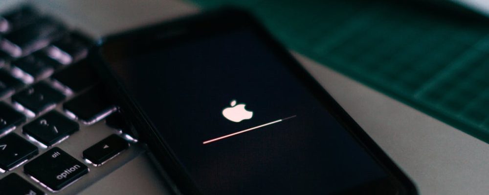 Close-up of a smartphone charging on a laptop. Ideal for tech themes.