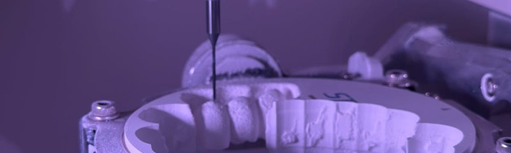 Detailed view of CNC machine milling process with purple lighting, highlighting precision engineering.