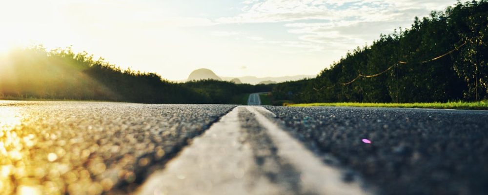 Serene road stretching through lush landscape during sunset in Kangar, Malaysia.