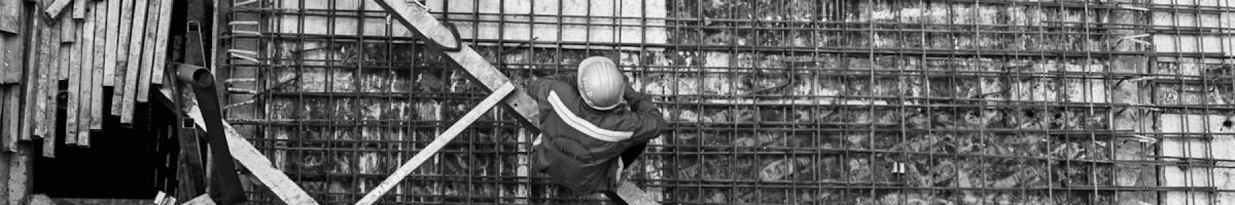 High angle view of a worker at a construction site captured in black and white.
