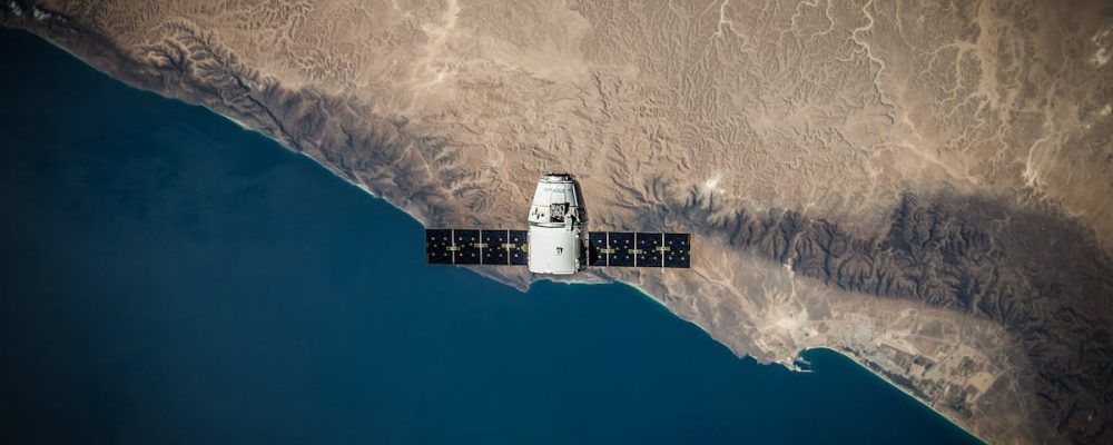 A satellite hovering above Earth's coastline, captured from space.