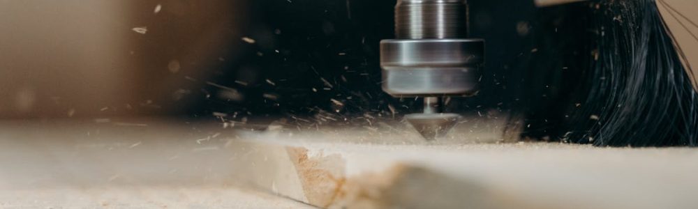 CNC machine in action, precisely cutting a wooden panel with sawdust flying.