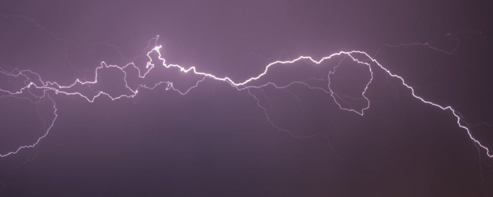 A vivid display of lightning bolts illuminating the night sky, capturing the electric power of a thunderstorm.