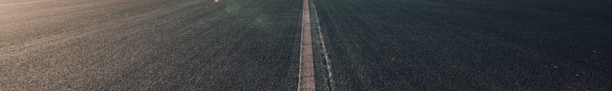 Expansive view of an empty road stretching into the distance under a clear blue sky in Utrecht, Netherlands.